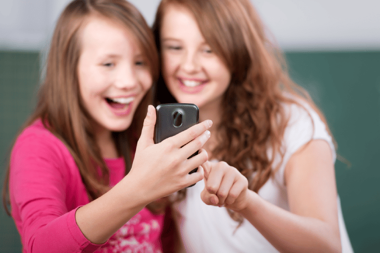 Two laughing students looking at the mobile phone_1